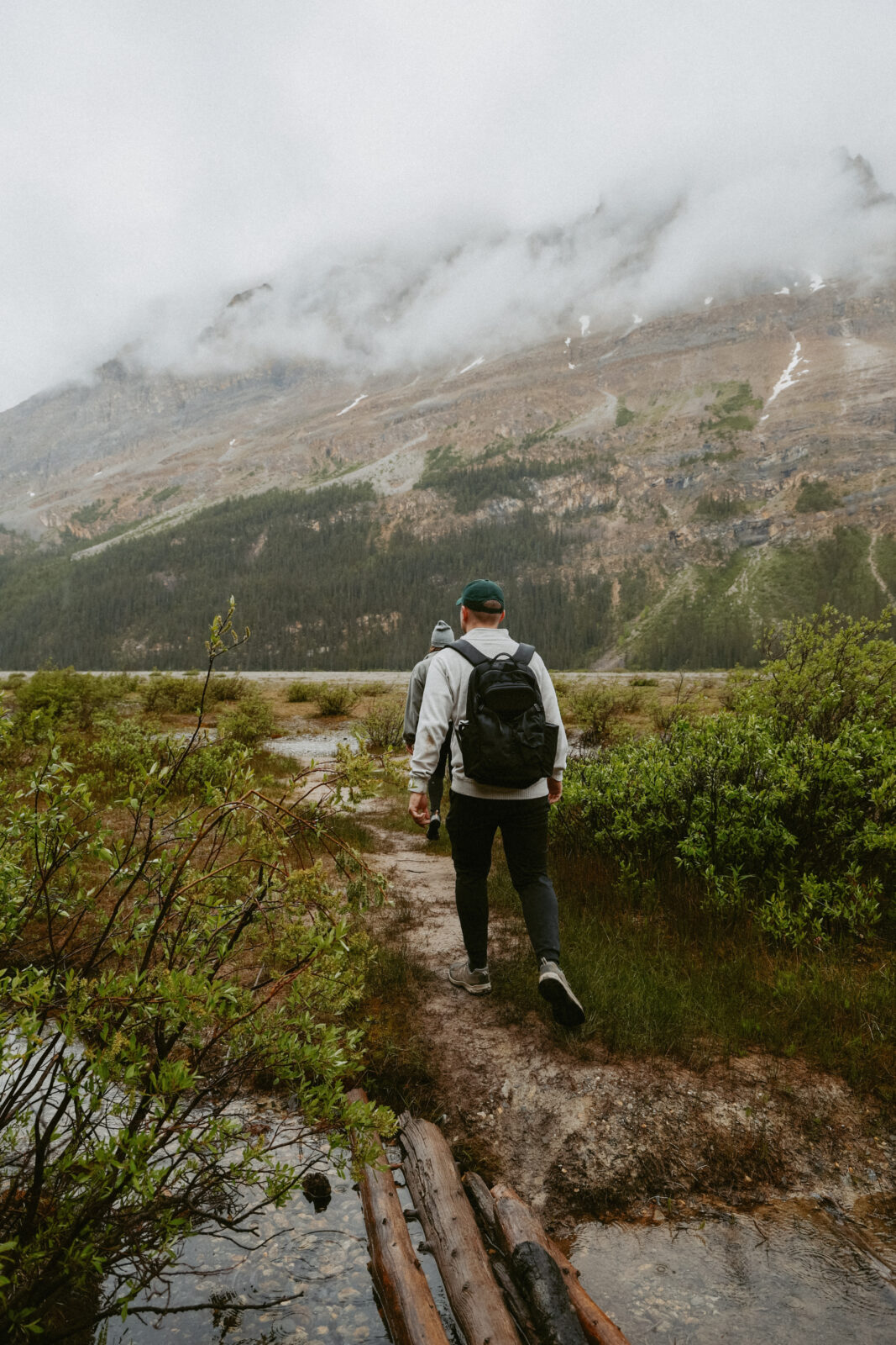 couples walks towards Alberta lake 