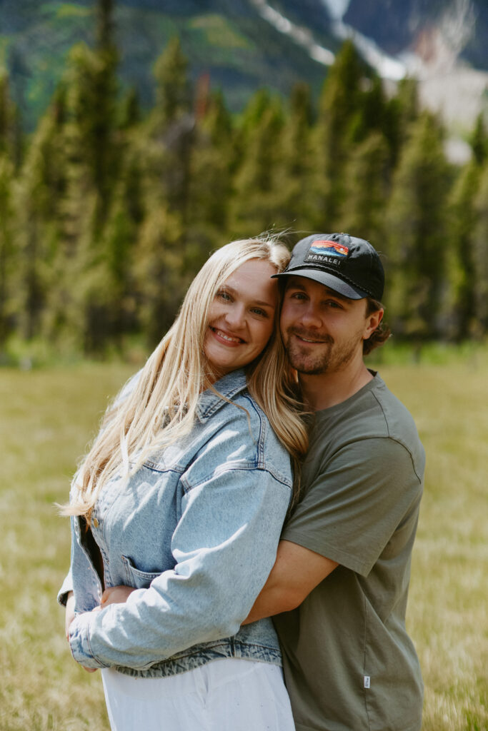 man wraps his arms around women's waist during engagement photoshoot. 
