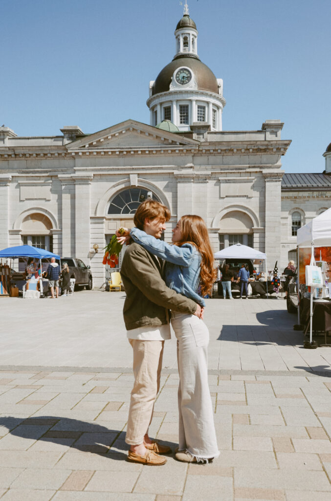 Couple hugs in front of City Hall, Kingston ON