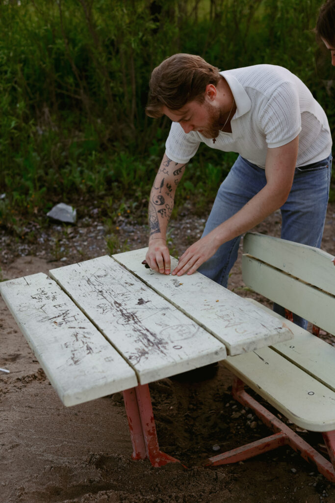 Couple etches names into old abandon table.