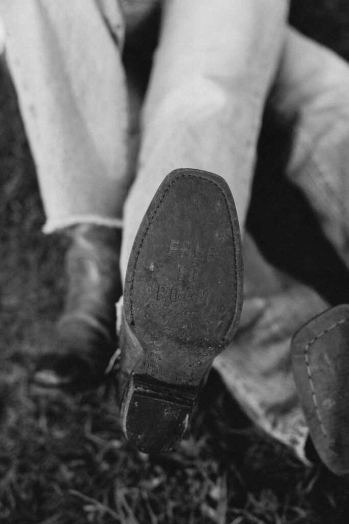 Bottom of cowboy boot that has writing "Free to Roam"