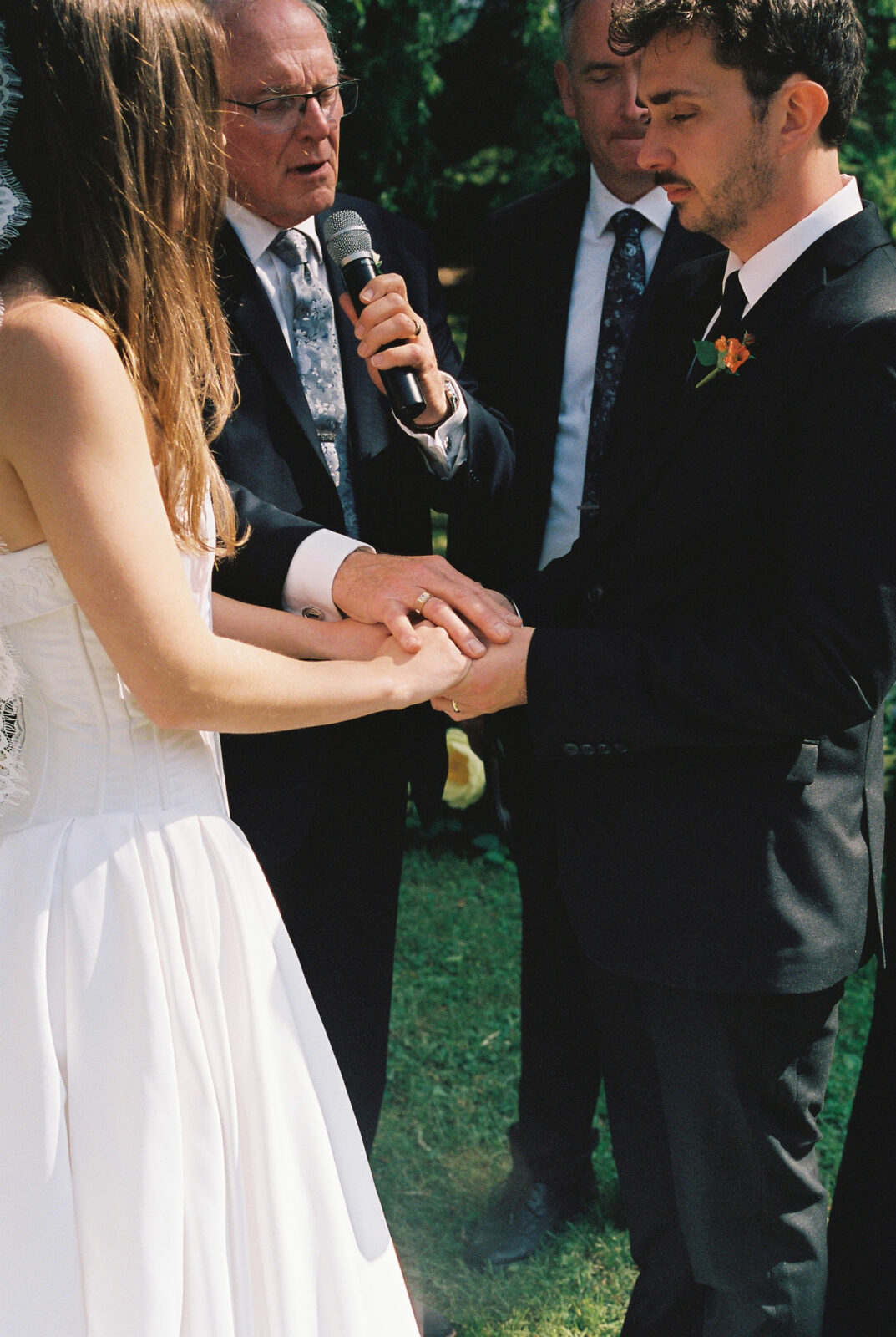 Bride and groom hold hands while getting married 