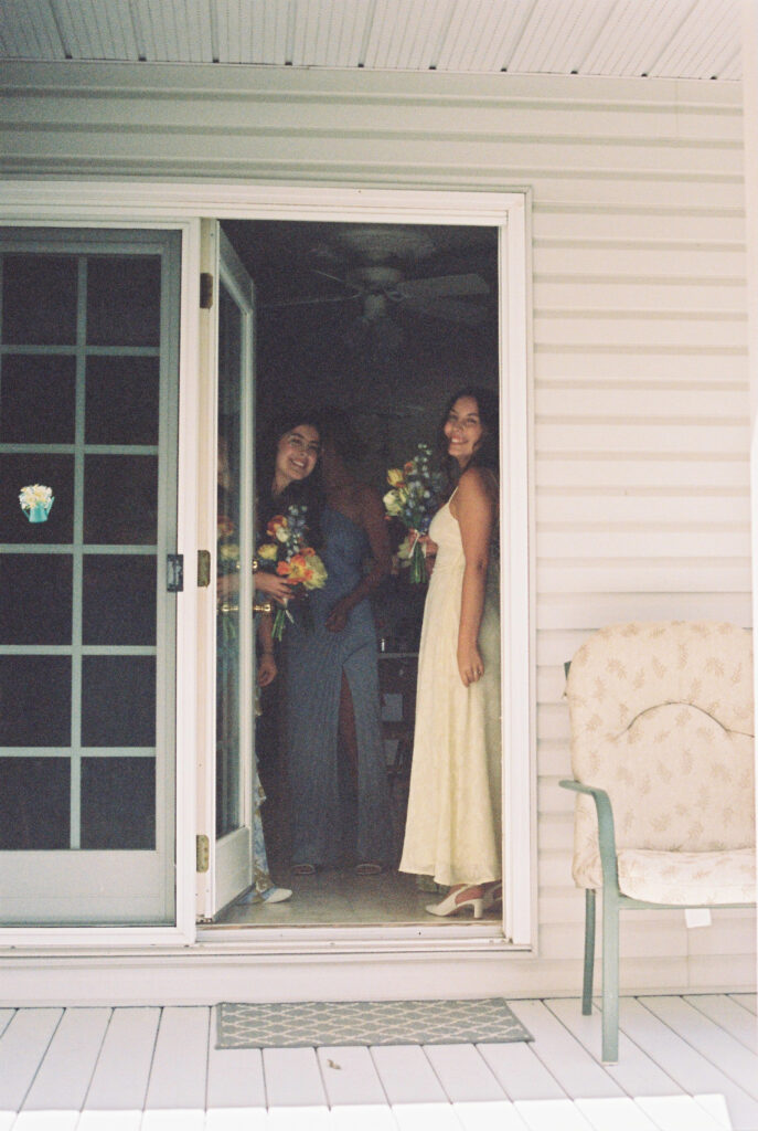 bridesmaid with flowers, standing in doorway.