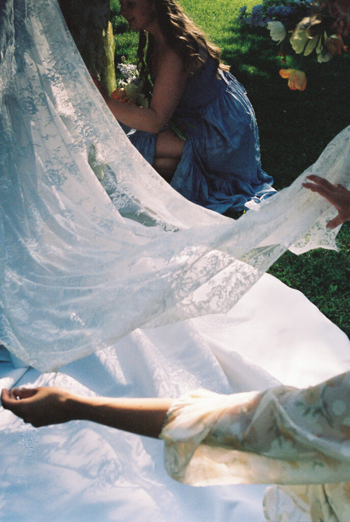 bride maid fluffs veil 